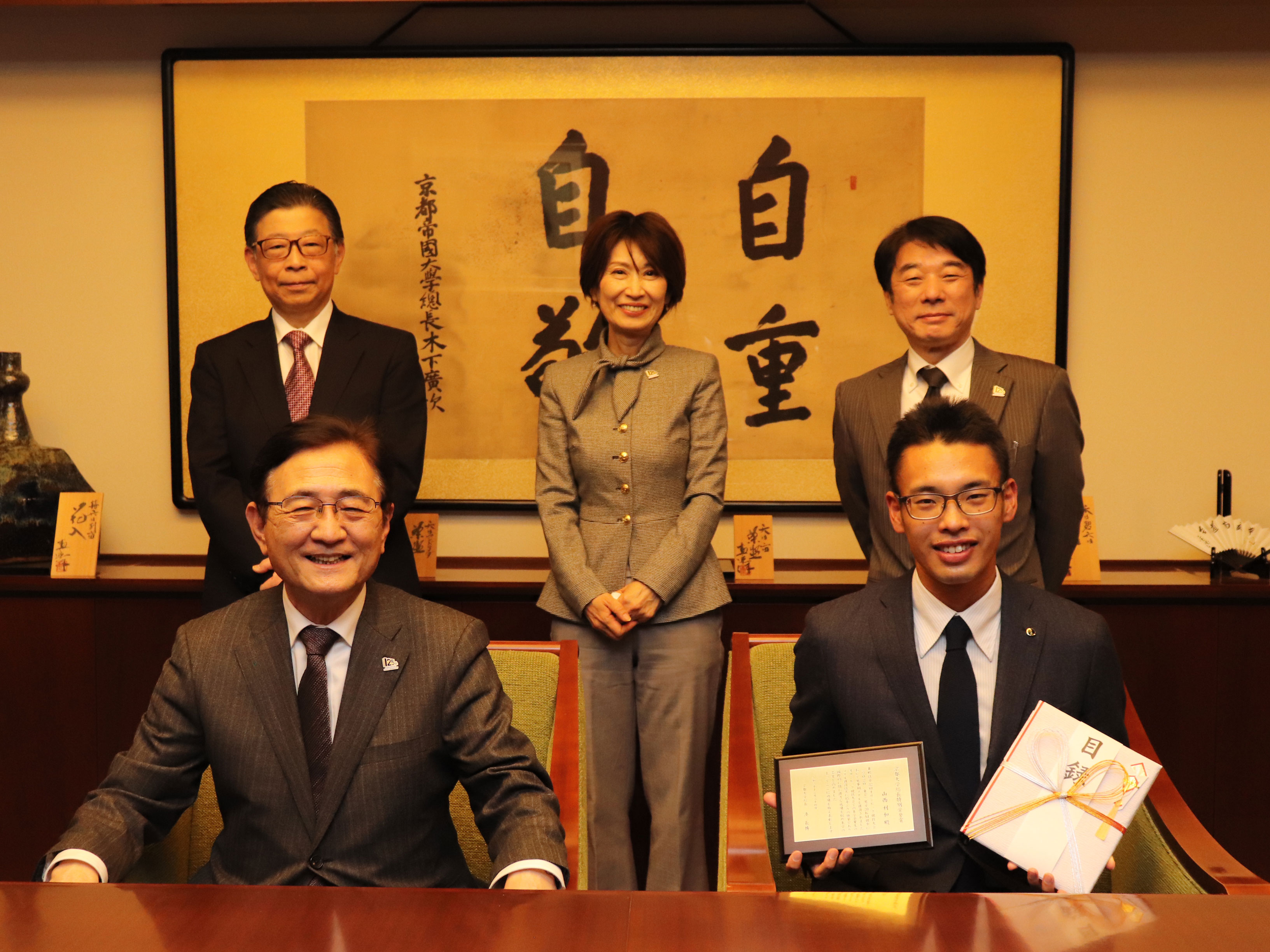 表彰状（盾）と目録が授与された山西氏