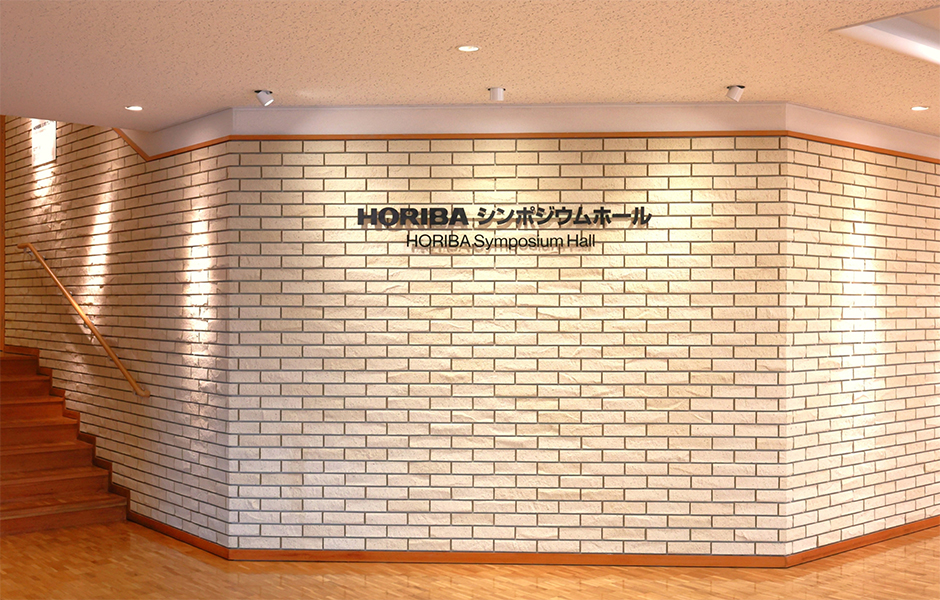 サインが表示されているシンポジウムホール入口正面の写真があります。